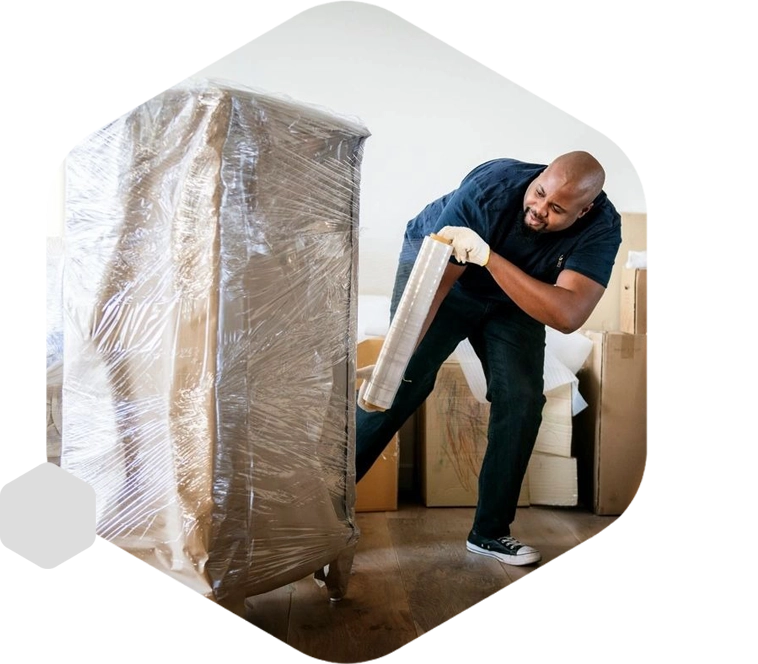 A man moving boxes in a room with a box on the floor.